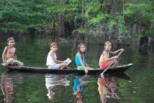 Un canoa navegando por un afluente del Amazonas