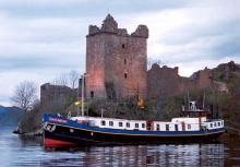 Foto del barco Scottish Higlander pasando al lado de un castillo