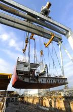 Imagen de una grua transportando parte de la embarcación del Magic